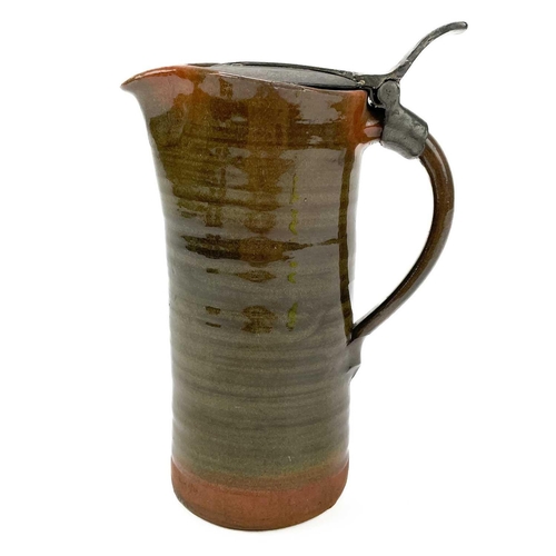 417 - A Leach Pottery an early red clay jug with a hinged pewter lid. Impressed marks, height 18cm. There ... 