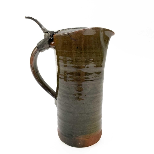 417 - A Leach Pottery an early red clay jug with a hinged pewter lid. Impressed marks, height 18cm. There ... 