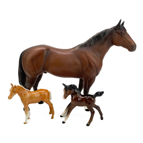 426 - A Beswick pottery quarter horse. Height 21.5cm together with two Beswick Pottery foals. (3)