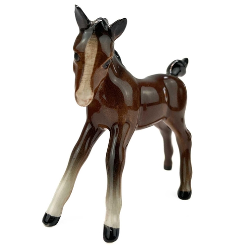 426 - A Beswick pottery quarter horse. Height 21.5cm together with two Beswick Pottery foals. (3)