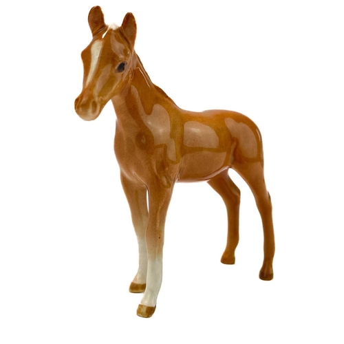 426 - A Beswick pottery quarter horse. Height 21.5cm together with two Beswick Pottery foals. (3)