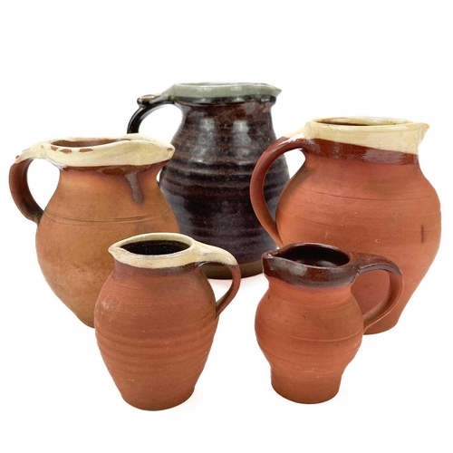 434 - Fred Bramham Hadleigh pottery jug, Height 18.5cm together with four graduating terracotta jugs, and ... 