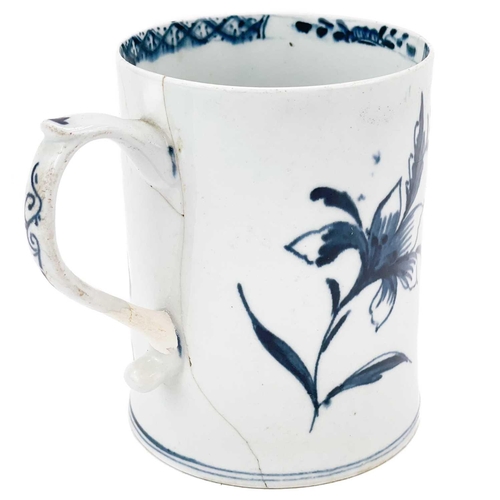 438 - A Lowestoft porcelain tankard. Decorated in blue and white with insects and flowers, height 11cm.