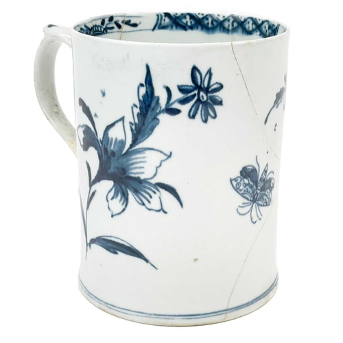 438 - A Lowestoft porcelain tankard. Decorated in blue and white with insects and flowers, height 11cm.