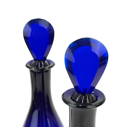 459 - A pair of George III Bristol blue glass Indian Club form decanters. With bevelled edge lozenge stopp... 