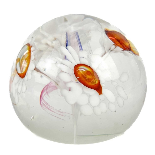 485 - Norman Stuart Clarke (b.1944). A studio glass paperweight decorated with four flowers, signed and da... 