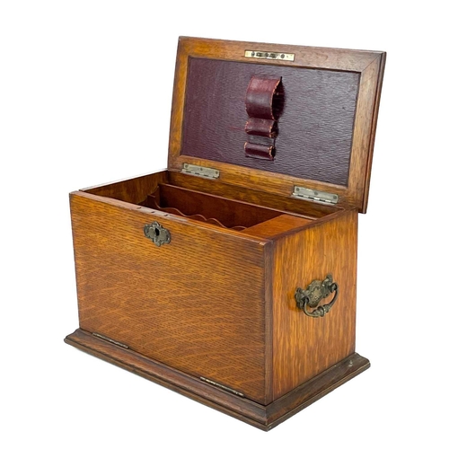 50 - An Edwardian oak stationery cabinet. With rising lid and drop front with a fold-down writing surface... 