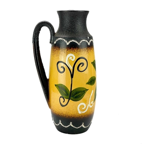 519 - A West German tall Lava jug. Decorated with a flower, height 47cm.