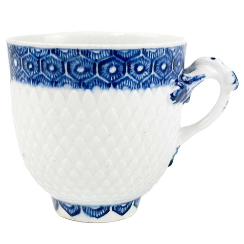 575 - An unusual Bow scale moulded and blue painted porcelain coffee cup. Circa 1760, the handle with leaf... 