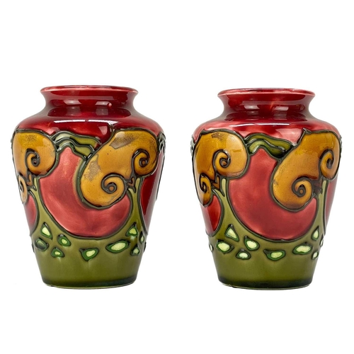 586 - A pair of Minton secessionist vases. Tube lined with stylised trees on a red and green ground, print... 