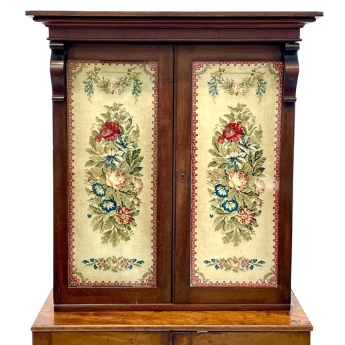 613 - A 19th century walnut and mahogany bookcase. With embroidered panels enclosing various shelves, the ... 