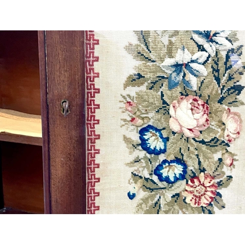 613 - A 19th century walnut and mahogany bookcase. With embroidered panels enclosing various shelves, the ... 