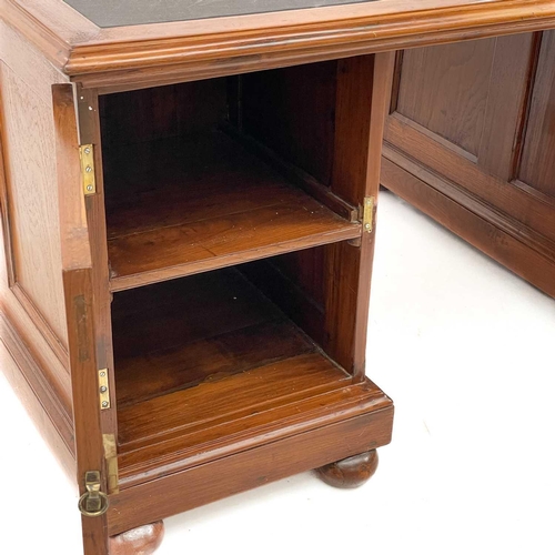 615 - A teak partners desk. Indian, mid 20th century, with a rexine writing surface, each pedestal fitted ... 