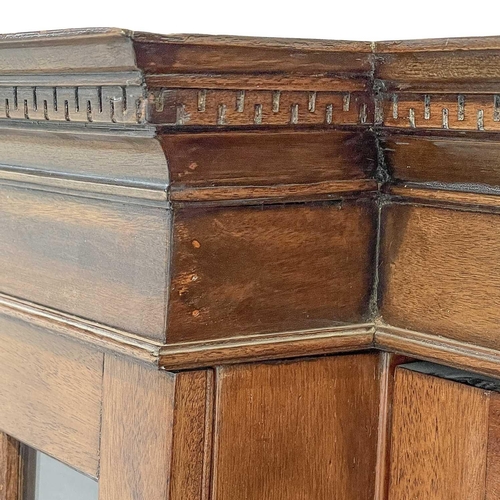 629 - A late Victorian breakfront bookcase. The moulded cornice above astragal glazed doors enclosing adju... 