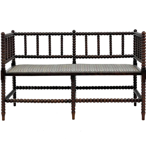 633 - A late Victorian stained beech bobbin turned settee. Of small proportions, with open back and padded... 