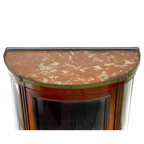 635 - A marble top mahogany vitrine. Circa 1900, with pierced brass gallery and of half round section, on ... 