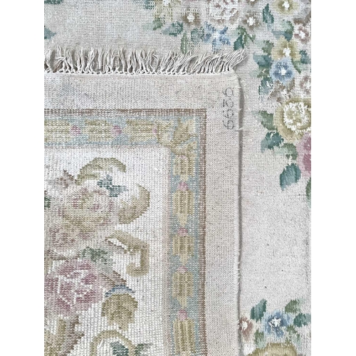 641 - A large Indian wool carpet. With a floral design on an off-white ground, 272X361cm