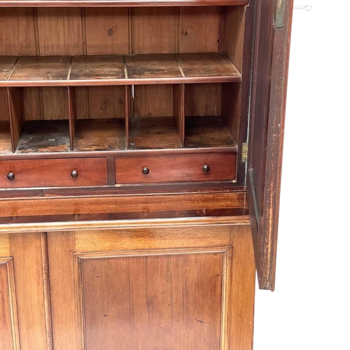 643 - A Victorian mahogany two-part estate cupboard. The upper part with a moulded cornice above two doors... 