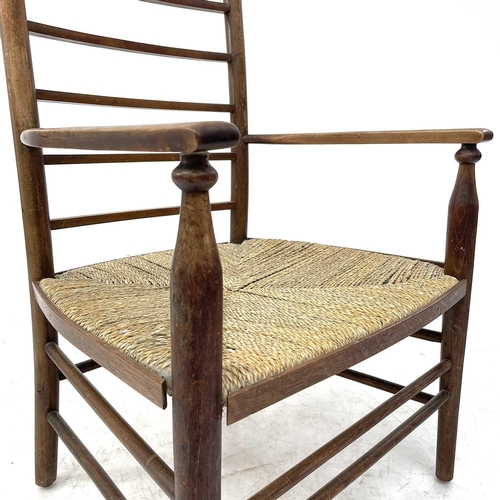 647 - A beech ladderback nursing chair labelled Liberty. With rush seat, height 85.5cm width 47cm depth 42... 