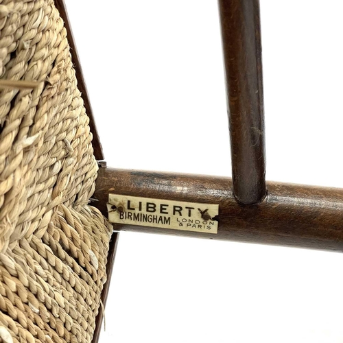 647 - A beech ladderback nursing chair labelled Liberty. With rush seat, height 85.5cm width 47cm depth 42... 