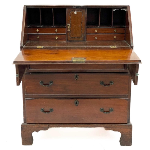 671 - A mahogany and oak bureau. 19th century, the fall front enclosing a fitted interior above three long... 