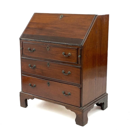 671 - A mahogany and oak bureau. 19th century, the fall front enclosing a fitted interior above three long... 