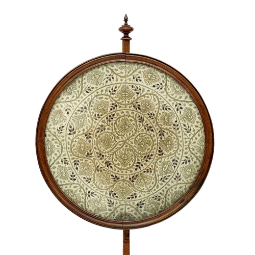 691 - A Victorian walnut pole screen. The circular banner with scrolling foliage in gilt metal thread, on ... 