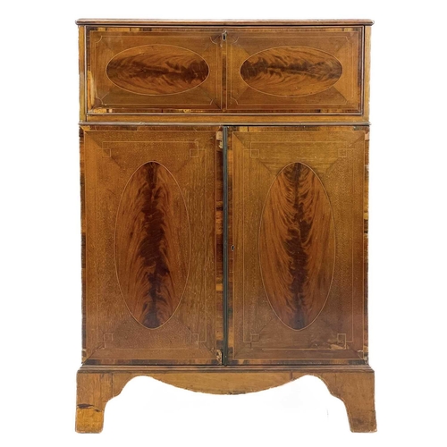 696 - A George III style mahogany secretaire. With oval figured and rosewood banded drop front, enclosing ... 