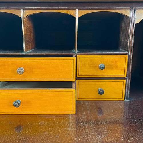 696 - A George III style mahogany secretaire. With oval figured and rosewood banded drop front, enclosing ... 