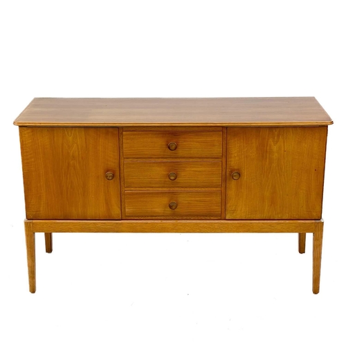 701 - A Gordon Russell Broadway walnut veneer sideboard. With three central drawers flanked by two cupboar... 