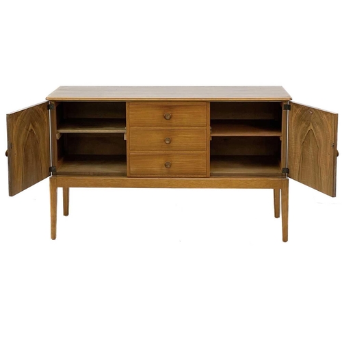 701 - A Gordon Russell Broadway walnut veneer sideboard. With three central drawers flanked by two cupboar... 