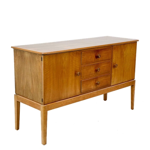 701 - A Gordon Russell Broadway walnut veneer sideboard. With three central drawers flanked by two cupboar... 