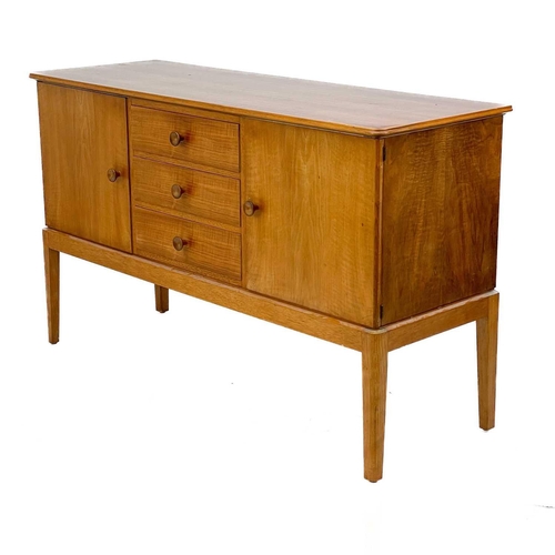 701 - A Gordon Russell Broadway walnut veneer sideboard. With three central drawers flanked by two cupboar... 