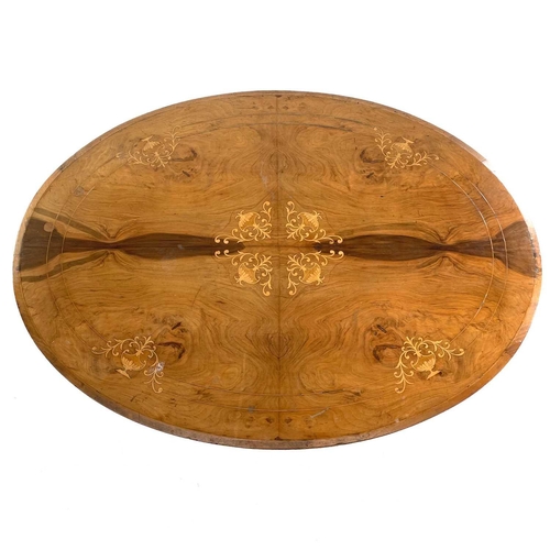 706 - A Victorian walnut inlaid loo table. The oval top with quarter veneer boxwood urn marquetry on turne... 