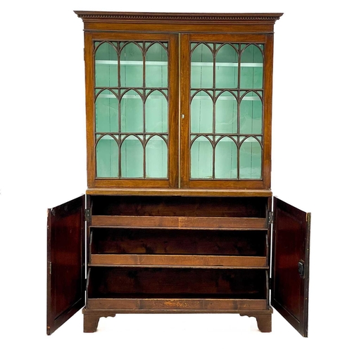 747 - A 19th century mahogany bookcase cabinet. With a dentil cornice above arched glazed doors, the lower... 