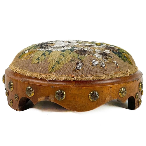 93 - A Victorian walnut footstool. With beadwork top and brass studded Gothic style decoration, diameter ... 