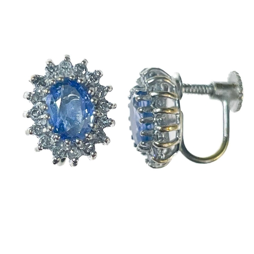 193 - A pair of 9ct white gold oval cornflower blue sapphire and diamond cluster screw back earrings. The ... 