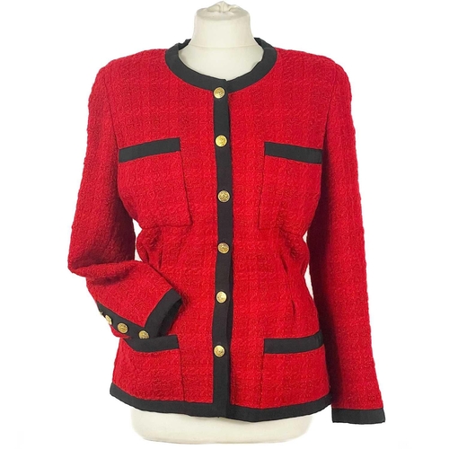 581 - A Chanel 1980's red boucle jacket with gold plated buttons and black trim. Label cut, size S approxi... 