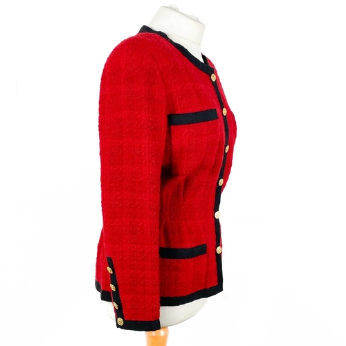 581 - A Chanel 1980's red boucle jacket with gold plated buttons and black trim. Label cut, size S approxi... 