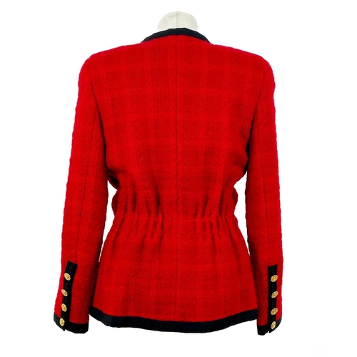 581 - A Chanel 1980's red boucle jacket with gold plated buttons and black trim. Label cut, size S approxi... 