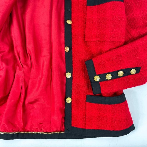 581 - A Chanel 1980's red boucle jacket with gold plated buttons and black trim. Label cut, size S approxi... 