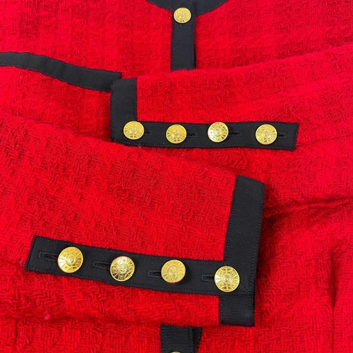 581 - A Chanel 1980's red boucle jacket with gold plated buttons and black trim. Label cut, size S approxi... 