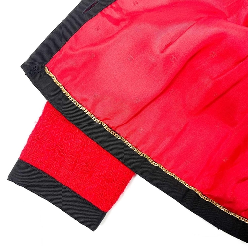 581 - A Chanel 1980's red boucle jacket with gold plated buttons and black trim. Label cut, size S approxi... 