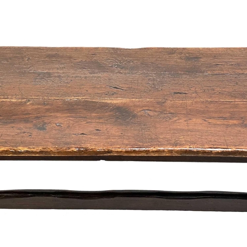 23 - An 18th century oak refectory table. With a rectangle plank top twin trestle supports on sledge feet... 