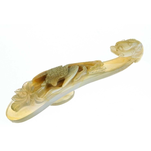 1004 - A Chinese agate belt hook, 18th century. The shaft carved with a bird amongst flowers, facing the dr... 