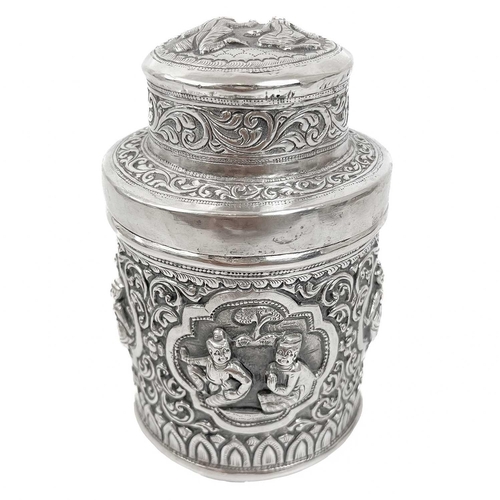 1017 - Two Burmese silver lidded cannisters, mid 20th century Repousse decorated witrh figures in landscape... 