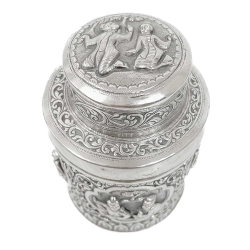 1017 - Two Burmese silver lidded cannisters, mid 20th century Repousse decorated witrh figures in landscape... 