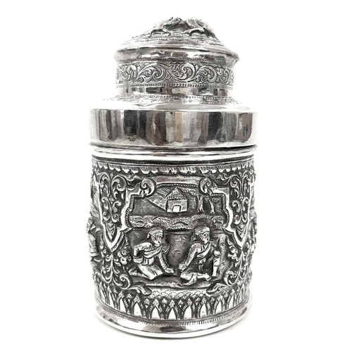 1017 - Two Burmese silver lidded cannisters, mid 20th century Repousse decorated witrh figures in landscape... 