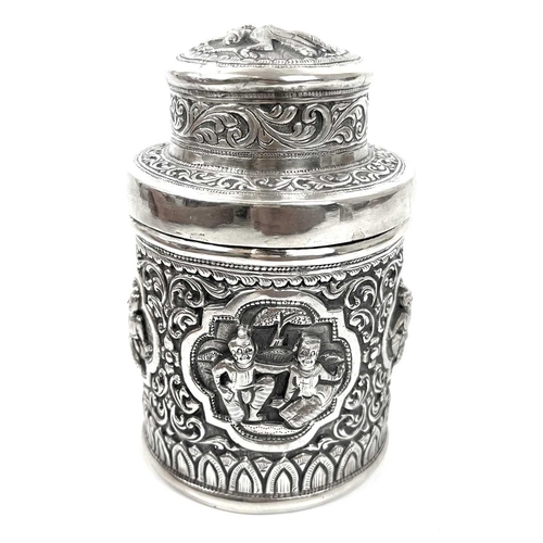 1017 - Two Burmese silver lidded cannisters, mid 20th century Repousse decorated witrh figures in landscape... 