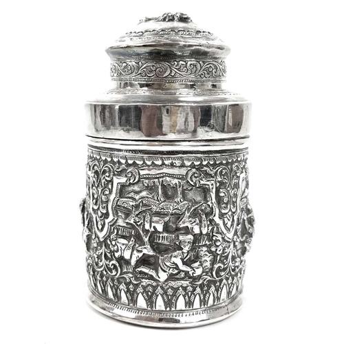 1017 - Two Burmese silver lidded cannisters, mid 20th century Repousse decorated witrh figures in landscape... 